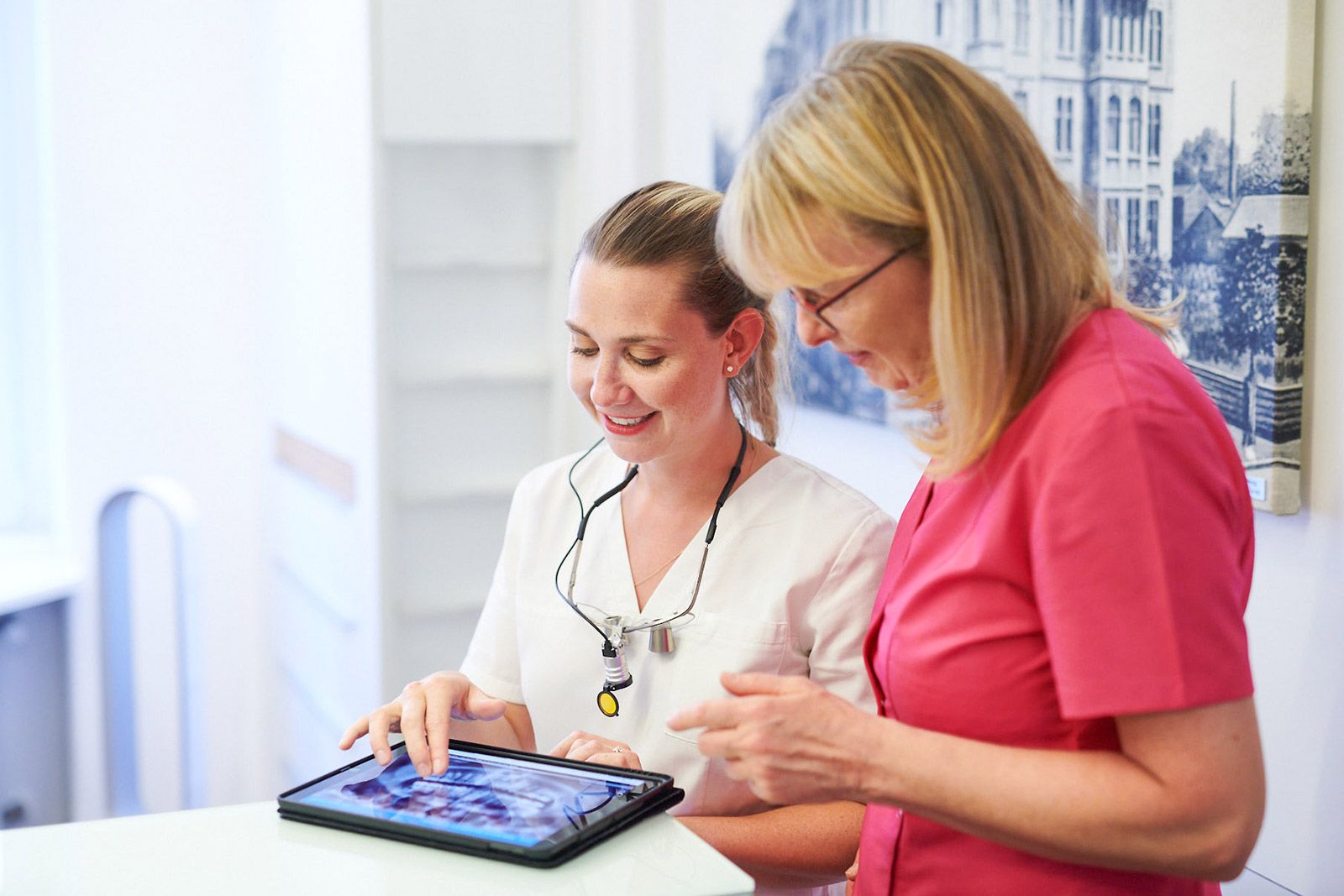 Dr. Sabrina Krüger und Assistenz Micheala Hammerschmidt besprechen gemeinsam ein Röntgenbild an einem Tablet