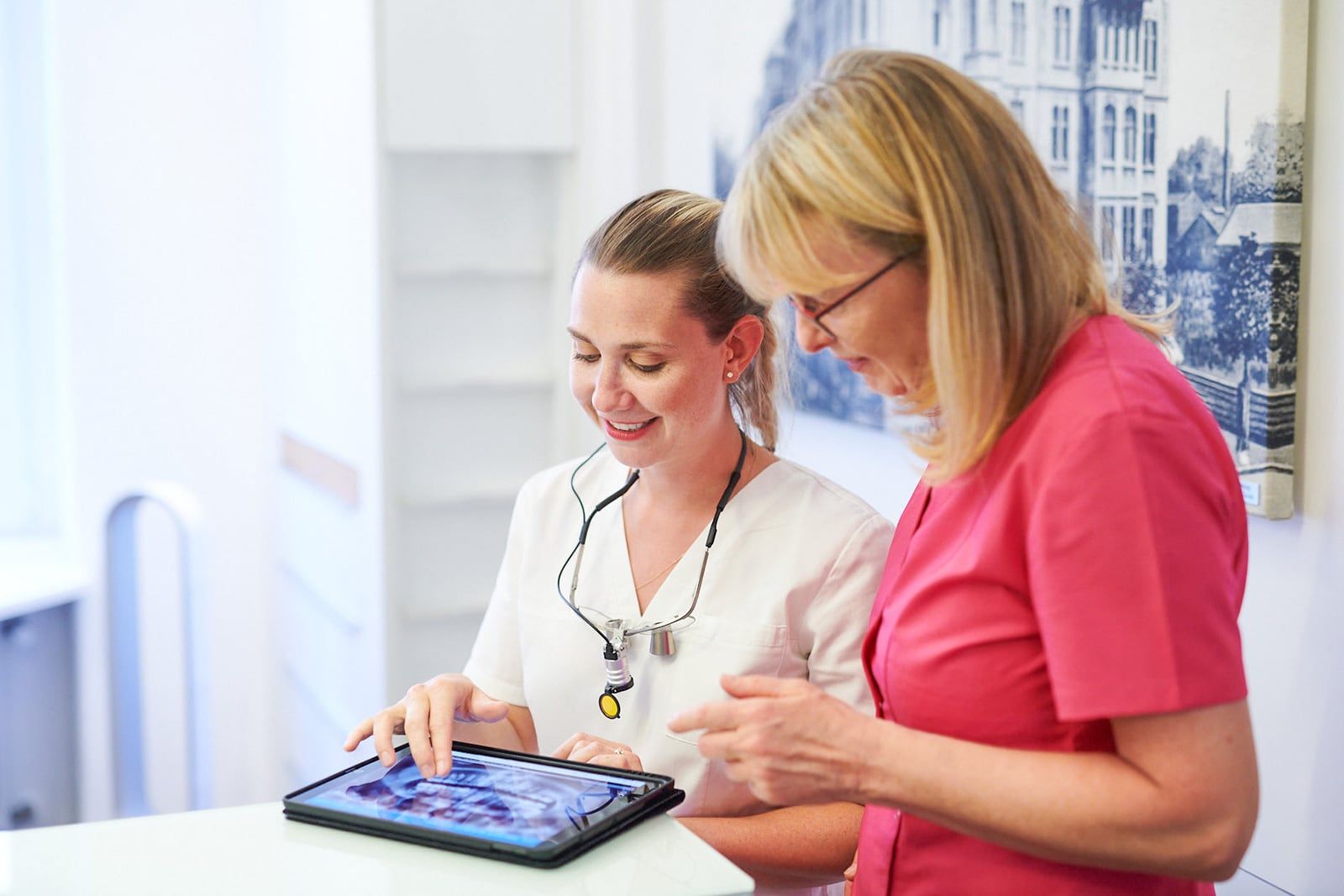 Dr. Sabrina Krüger und Assistenz Micheala Hammerschmidt besprechen gemeinsam ein Röntgenbild an einem Tablet