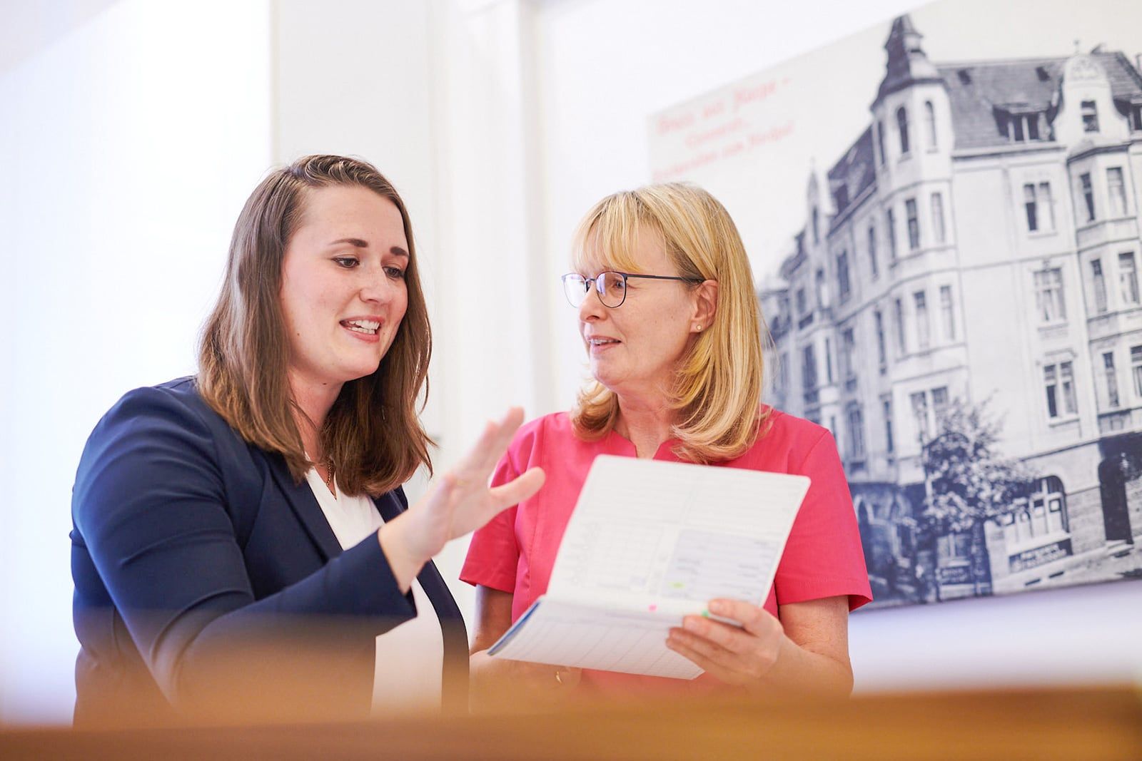 Frau Nora Bildheim (l.) und Frau Micheala Hammerschmidt (r.) schauen sich ein Abrechnungsschriftstück an