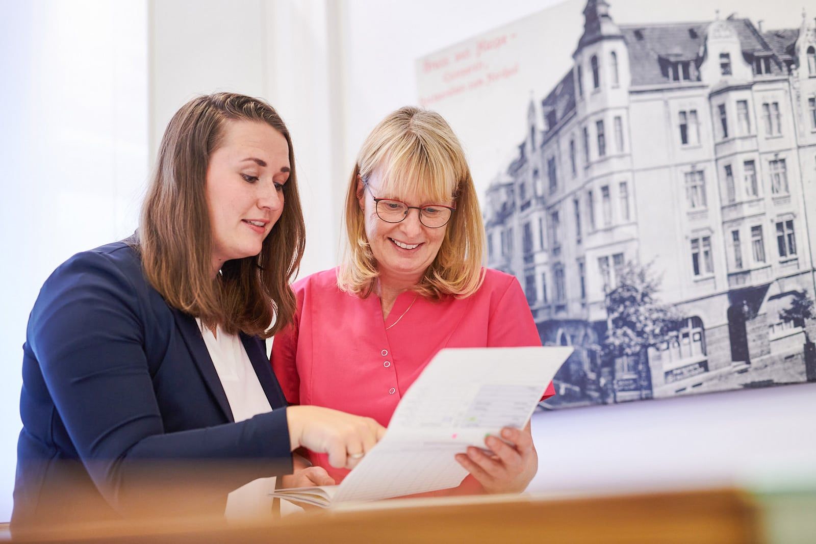 Frau Nora Bildheim (l.) und Frau Micheala Hammerschmidt (r.) schauen sich ein Abrechnungsschriftstück an